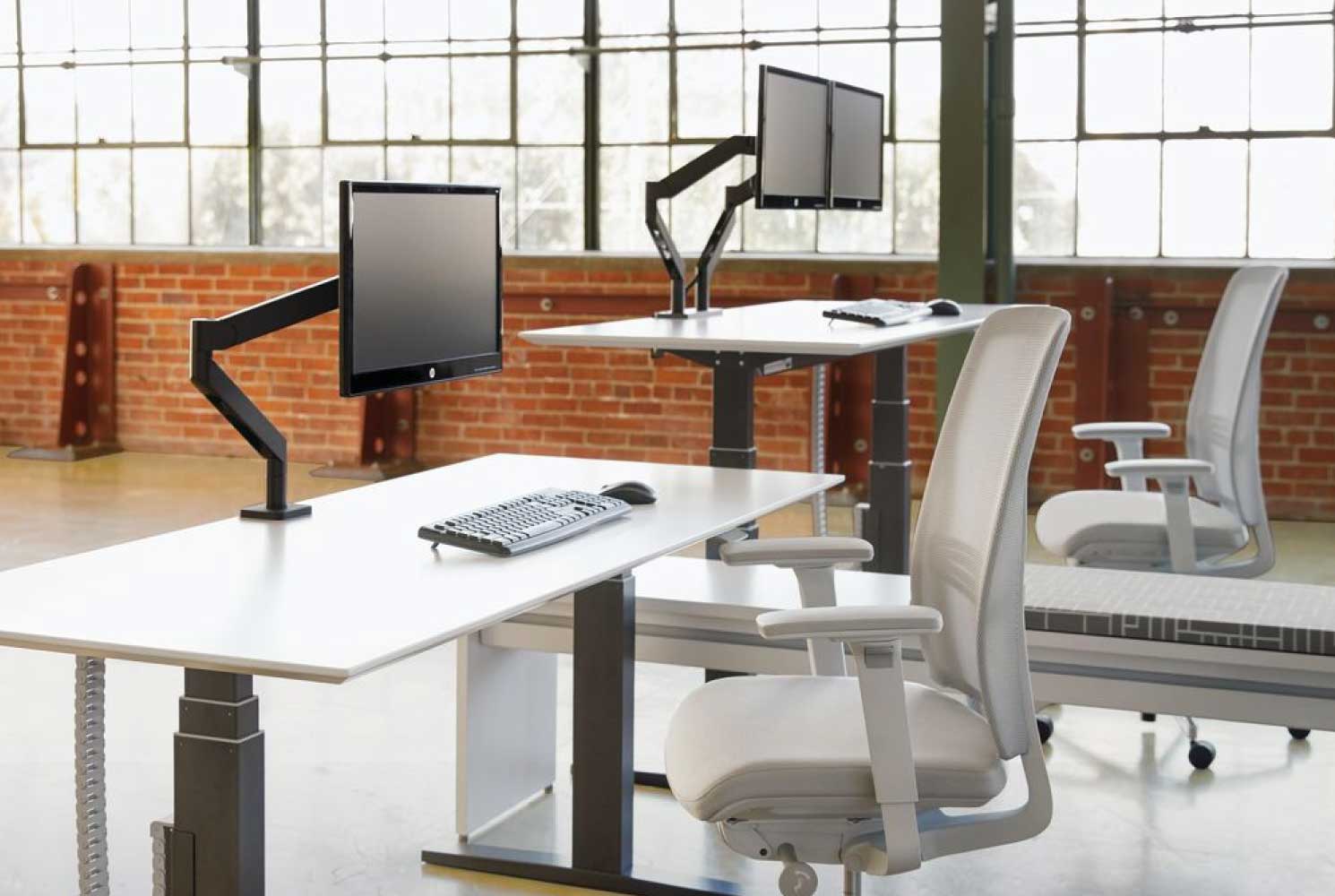 Sit stand desks with Teknion Swerve Monitor Arms